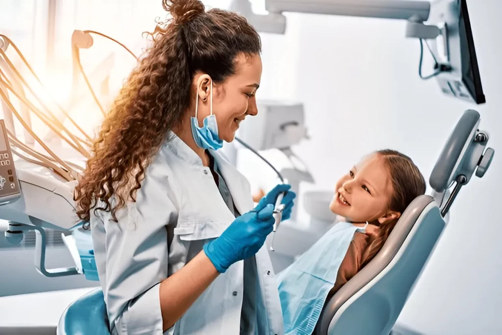 Pediatric dentist interacting with a smiling child patient during a dental checkup